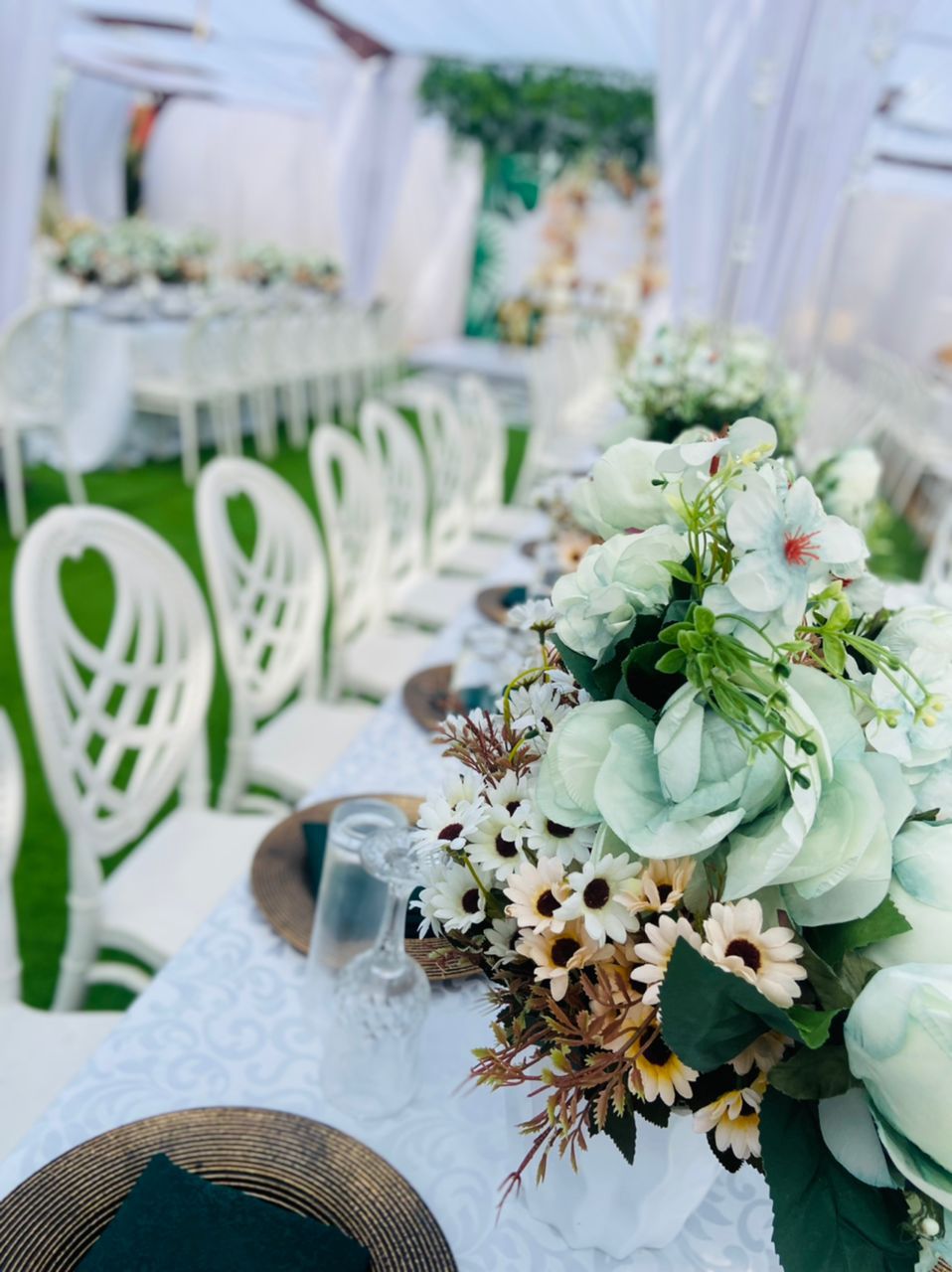 Green and white themed table setup with floral centerpieces