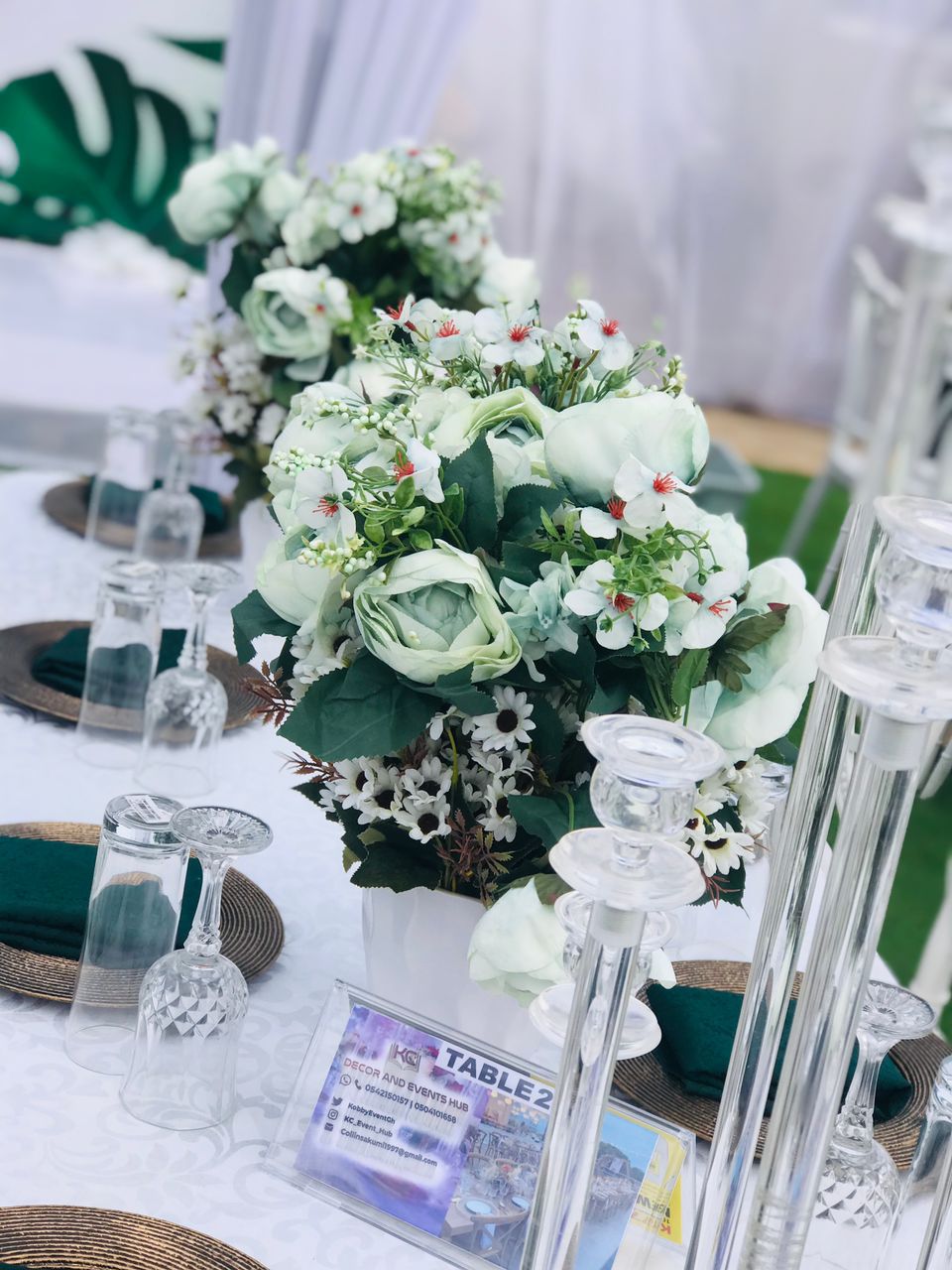 Beautifully styled round table with green floral arrangements